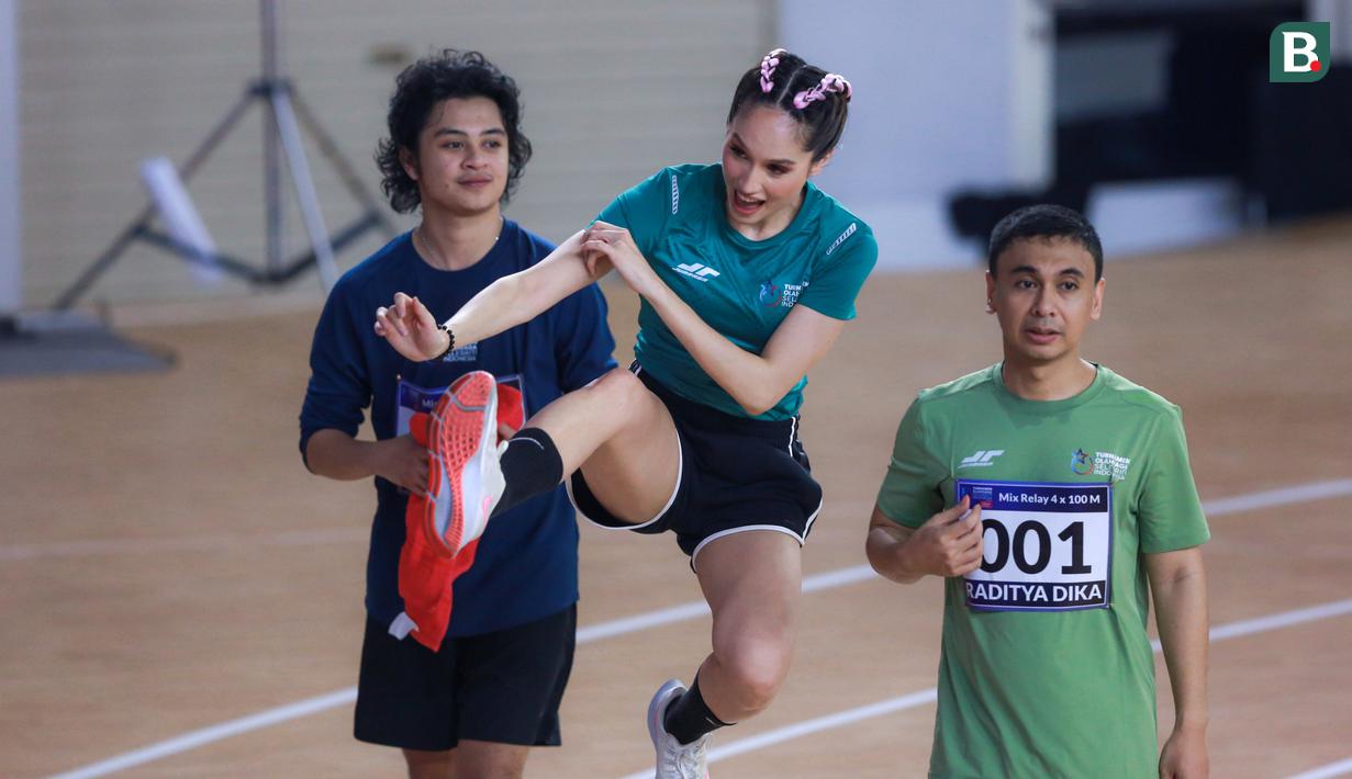 Selebritas Indonesia, Cinta Laura (tengah) melakukan selebrasi setelah timnya berhasil memenangkan lomba lari estafet 400 meter nomor campuran Turnamen Olahraga Selebriti Indonesia (TOSI) di GOR UNJ, Rawamangun, Jakarta, Minggu (30/07/2023). Timnya berhasil finis dengan catatan waktu 1 menit 0,59 detik. (Bola.com/Bagaskara Lazuardi)