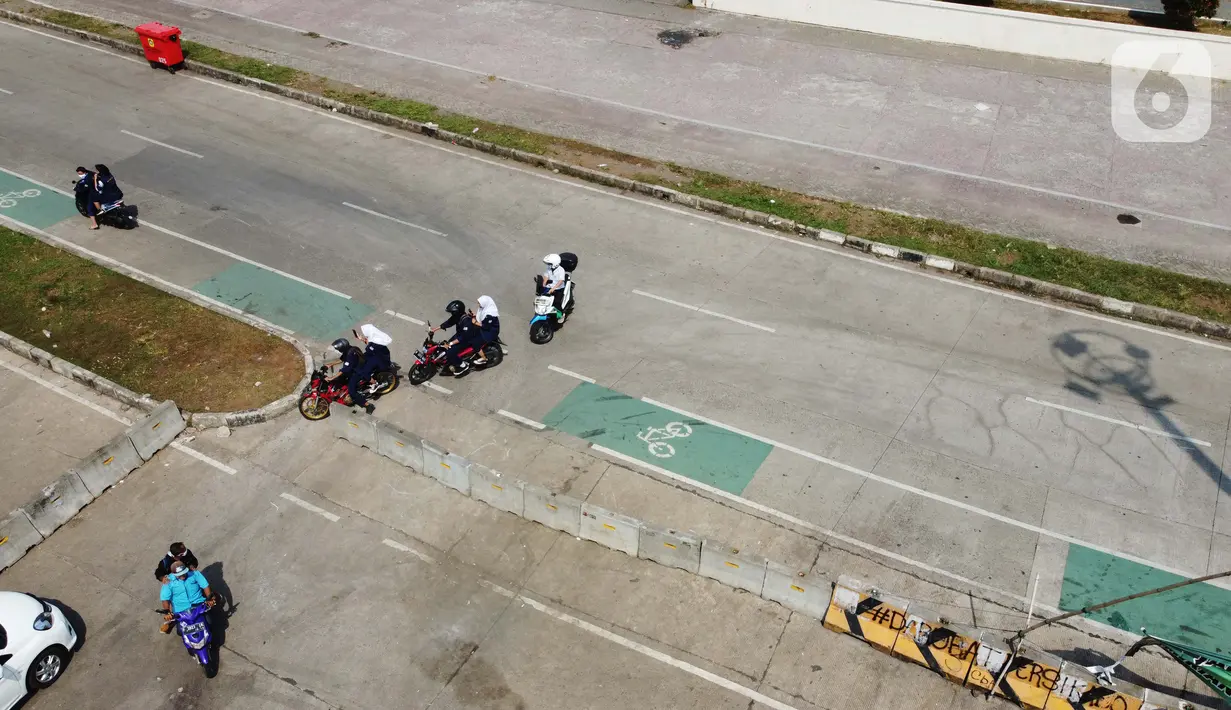 Pengendara motor menerobos beton pembatas di kawasan lingkar Stadion Pakansari, Kabupaten Bogor, Jawa Barat, Rabu (10/6/2020). Pemkab Bogor masih melakukan Pembatasan Sosial Berskala Besar (PSBB) secara proporsional hingga 2 Juli mendatang. (Liputan6.com/Helmi Fithriansyah)
