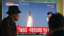 Seorang pria melewati layar televisi yang menyiarkan berita peluncuran rudal oleh Korea Utara (Korut), di sebuah stasiun kereta di Seoul, Korea Selatan, Selasa (5/4). Rudal itu ditembakkan dari wilayah timur Korut ke arah Laut Jepang. (JUNG Yeon-Je/AFP)