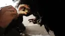 Seorang pecandu memasukan cairan ke dalam jarum suntiknya di bawah jembatan yang menjadi pusat penggunaan heroin di Kensington, Philadelphia (24/1). (Spencer Platt/Getty Images/AFP)