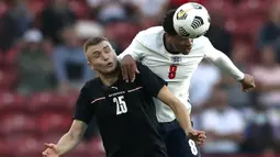 Gelandang Inggris, Jude Bellingham (kanan) berduel udara dengan striker Austria, Sasa Kaladzic dalam laga uji coba menjelang berlangsungnya Euro 2020 di Riverside Stadium, Middlesbrough, Rabu (2/6/2021). Inggris menang 1-0 atas Austria. (AP/Scott Heppell/Pool)