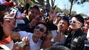 Pebalap Manor F1 Team, Rio Haryanto bertemu fans yang telah menunggu untuk menyaksikan balapan perdana Formula One Australian Grand Prix, Melbourne, Minggu (20/3/2016). (AFP/Paul Crock)