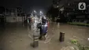 Warga melintasi banjir di Jalan Kemang Raya, Jakarta Selatan, Selasa (4/10/2022). Hujan yang mengguyur wilayah Ibu Kota Jakarta mengakibatkan banjir menggenangi kawasan Kemang, Jakarta. (Liputan6.com/Johan Tallo)