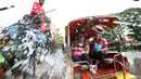 Seorang pawang menunggang gajah yang menyemprotkan air kepada wisatawan saat perayaan tahun baru kuno Thailand atau Songkran di provinsi Ayutthaya, Thailand (11/4). Songkran merupakan salah satu perayaan Tahun Baru Thailand. (AP Photo/Sakchai Lalit)