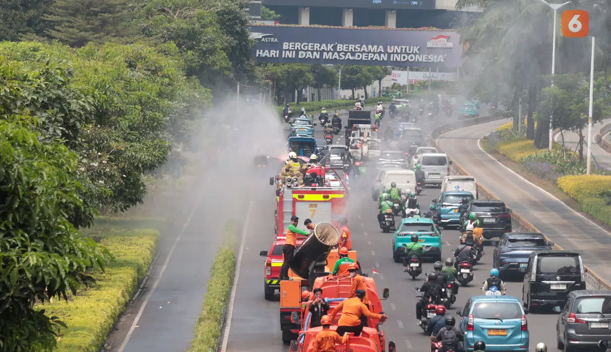 Petugas gabungan menyemprotkan air di kawasan jalan utama Jakarta yang terdampak sebaran abu vulkanik Gunung Anak Krakatau, sebagai langkah mengurangi partikel debu di permukaan jalan. (KLY/Budy Santoso)