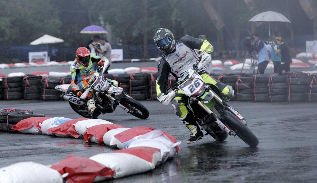 Pebalap muda Indonesia, Diva Ismayana (kiri) mencoba mengejar Natthapat Suksanwatt (kanan)  pada ajang FIM Asia Supermoto 2016 di Kompleks Stadion Kanjuruhan, Malang, Minggu (9/10/2016) (Bola.com/Reza Bachtiar)