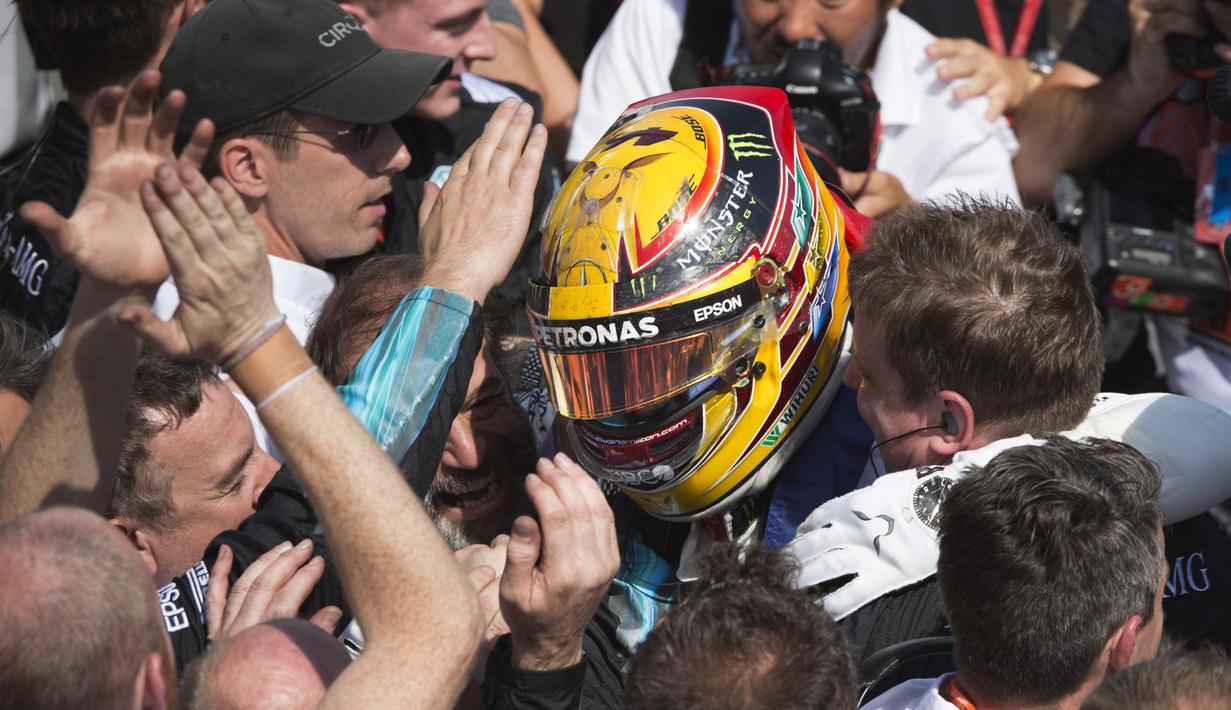 Pebalap Mercedes, Lewis Hamilton dikerubutin awak timnya usai menjuarai ajang Formula One Canadian Grand Prix di Montreal, Canada, (11/6/2017).  (Tom Boland/The Canadian Press via AP)