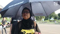 Ibu Ati, salah satu korban penggusuran Teluk Gong 2001 saat aksi Kamisan di depan Istana Negara, Jakarta, Kamis (14/2). Lewat aksi Kamisan, JSKK meminta komitmen pemerintah menyelesaikan kasus pelanggaran HAM masa lalu. (Liputan6.com/Helmi Fithriansyah)