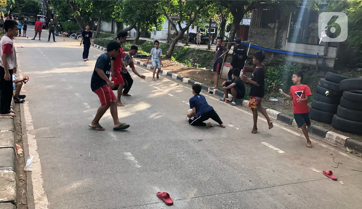 Anak-anak bermain di sekitar bantaran Kanal Banjir Timur (KBT), kawasan Cipinang Muara, Jakarta, Selasa (16/6/2020). Sebagian besar warga masih mengabaikan protokol kesehatan dengan tidak menjaga jarak serta tanpa menggunakan masker. (Liputan6.com/Immanuel Antonius)