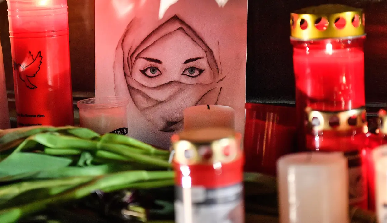 Gambar seorang wanita terlihat di antara lilin dan bunga saat berkabung untuk para korban penembakan brutal di Hanau, Jerman, Kamis (20/2/2020). Penembakan yang terjadi di dua bar shisha Kota Hanau menewaskan sembilan orang dan melukai sejumlah orang lainnya. (AP Photo/Martin Meissner)