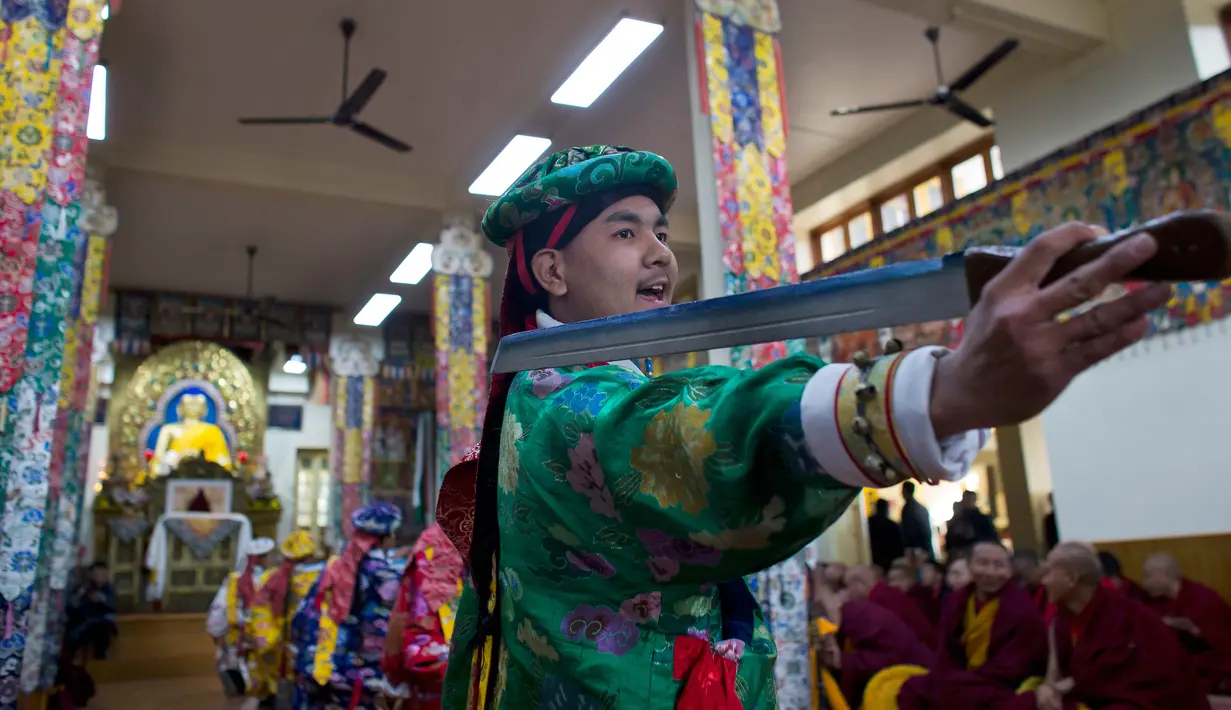 Seniman Tibet melakukan tarian pedang saat menyambut Tahun Baru mereka yang disebut Losar di Dharmsala, India (16/2). (AP/Ashwini Bhatia)