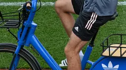 Penyerang Jerman, Thomas Mueller tiba dengan sepeda sebelum sesi latihan menjelang UEFA EURO 2020 di World of Sports Campus di Herzogenaurac (11/6/2021). Pada pertemuan pertama, Jerman akan bertemu Prancis pada grup F di Allianz Arena, Rabu (16/6). (AFP/Christof Stache)