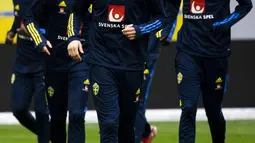 Pemain Swedia Emil Forsberg, Victor Nilsson Lindelof dan Alexander Isak melakukan pemanasan selama sesi latihan di Friends Arena di Solna, Senin (11/10/2021). Swedia akan menjamu Yunani pada lanjutan Kualifikasi Piala Dunia 2022 zona Eropa Grup B pada Rabu dini hari WIB. (LUNDAHL/TT News Agency/AFP)