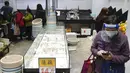 Seorang wanita bermasker berdiri dekat rak produk kosong saat penduduk khawatir kekurangan makanan segar di sebuah pasar di Hong Kong, 28 Februari 2022. Pada 28 Februari 2022, Hong Kong melaporkan rekor tertinggi kasus COVID-19 yaitu sebanyak 34.466. (AP Photo/Vincent Yu)