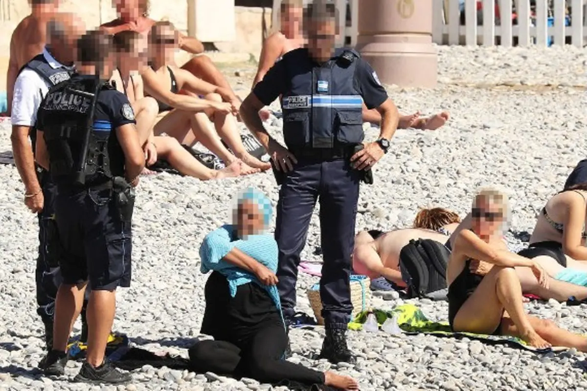 Foto polisi menjatuhkan denda pada perempuan yang mengenakan burkini memicu kontroversi di Prancis