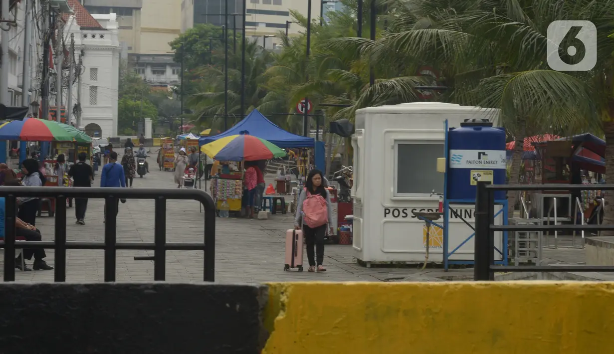 Sejumlah warga berada di kawasan Kota Tua, Jakarta, Jumat (31/12/2021).  Menyambut pergantian malam Tahun Baru 2022, kawasan kota Tua ditutup untuk sementara pada 31 Desember 2021 hingga 1 Januari 2022 untuk mencegah keramaian dan penyebaran Covid-19 varian Omicron. (merdeka.com/Imam Buhori)
