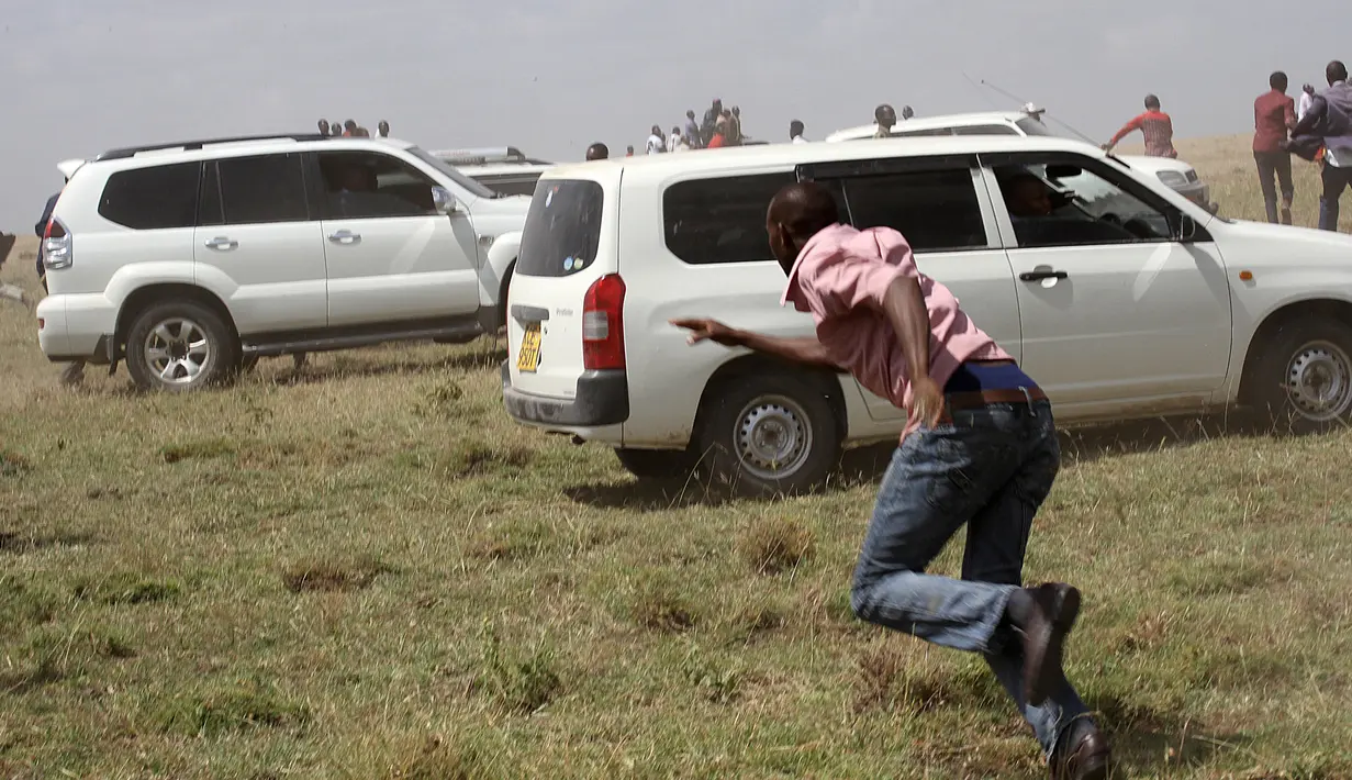 Warga berlarian ke tempat yang aman setelah seekor singa menyerang dan melukai pejalan kaki, di luar ibu kota Kenya, Nairobi, Rabu (30/3). Ini adalah kali keempat singa berkeliaran keluar dari Taman Nasional Nairobi. (REUTERS/Stringer)