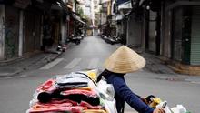 Seorang penjual berjalan melewati jalan sepi di tengah kekhawatiran tentang penyebaran Virus Corona COVID-19 di Hanoi Vietnam pada 26 Maret 2020. (Nhac Nguyen / AFP)