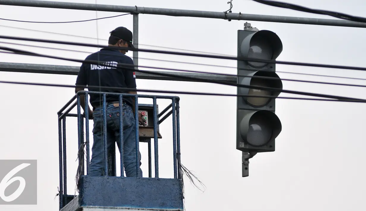 Petugas Dinas Perhubungan DKI Jakarta mengecek lampu lalu lintas di kawasan Manggarai, Jakarta, Selasa (19/7). Untuk mencegah kemacetan akibat trafic light, Dishub ganti lampu lalin yang bermasalah. (Liputan6.com/Yoppy Renato)
