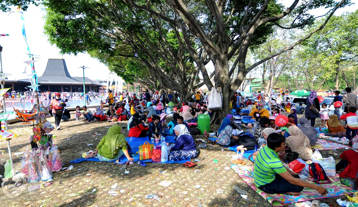 Sejumlah pengunjung beristirahat di area wisata Taman Mini Indonesia Indah, Jakarta, Minggu (19/07/2015). Makan bersama sambil menggelar tiker di tempat wisata menjadi pilihan warga yang mengunjungi tempat wisata TMII. (Liputan6.com/Yoppy Renato)