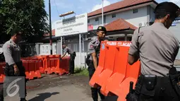 Polisi satuan Brimob mengangkat Water Barrier untuk barikade pengamanan menuju Dermaga Nusakambangan, Cilacap, Jawa Tengah, Rabu (27/7). Menjelang eksekusi Tahap 3 sejumlah persiapan dilakukan oleh Lapas Nusakambangan. (Liputan6.com/Helmi Afandi)