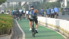 Warga bersepeda di jalan Sudirman, Jakarta, Selasa (1/6/2021). Direktorat Lalu Lintas Polda Metro Jaya tengah mengkaji sanksi sita sepeda apabila menemukan pesepeda yang gowes di luar jalur khusus yang telah disediakan. (merdeka.com/Imam Buhori)