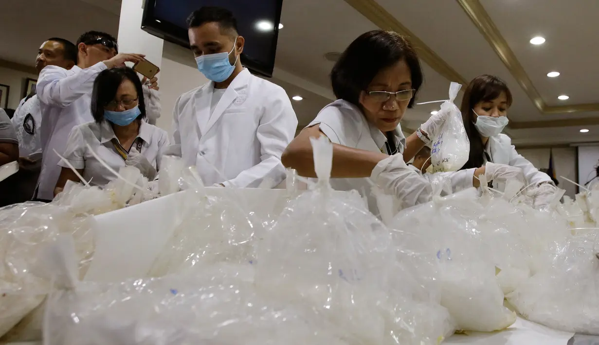 Petugas memeriksa bungkusan berisi metamfetamin yang diselundupkan dari China, di Kantor Biro Investigasi Nasional Filipina, Senin (29/5). Menurut pejabat setempat, ini adalah penyergapan kasus narkoba terbesar oleh Filipina. (AP Photo/Aaron Favila)