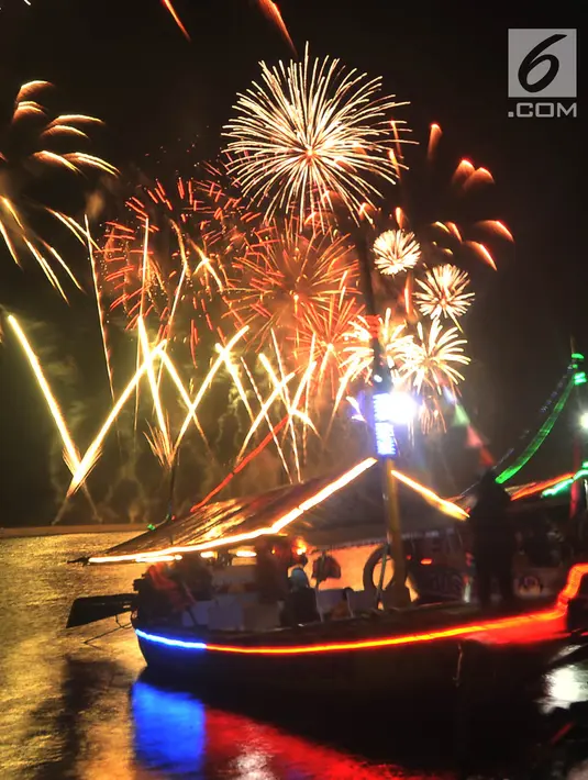 Pengunjung menyaksikan pesta kembang api saat malam Tahun Baru 2019 di Pantai Lagoon, Ancol, Jakarta, Selasa (1/1). Ancol menyajikan pesta kembang api musikal sepanjang 600 meter di bibir pantai dalam menyambut Tahun Baru 2019. (Merdeka.com/Iqbal Nugoho)