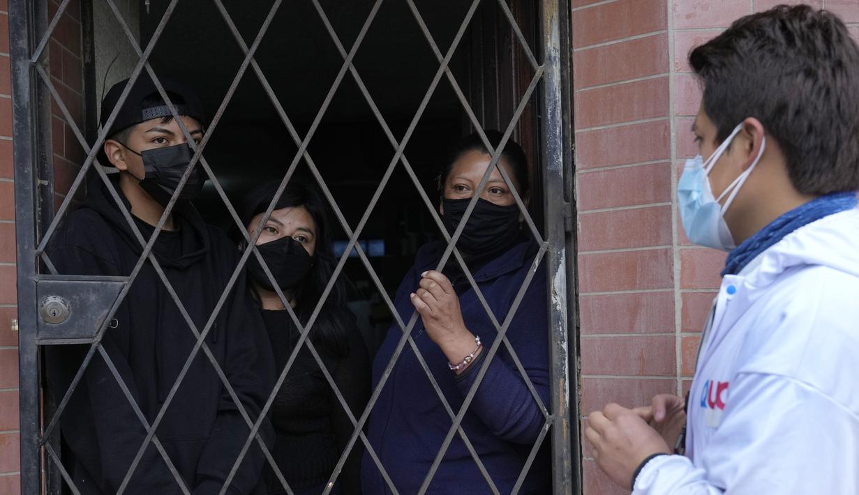 Brigade campuran dari pemerintah kota dan Kementerian Kesehatan mengunjungi lingkungan miskin untuk mendeteksi kasus COVID-19 dan melakukan vaksinasi, di Quito, Ekuador, Rabu (26/1/2022). (AP Photo/Dolores Ochoa)