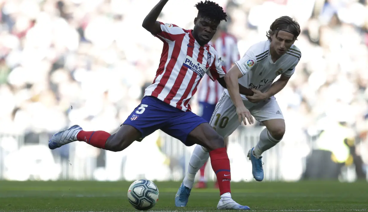 Gelandang Real Madrid, Luka Modric berusaha merebut bola yang dibawa gelandang Atletico Madrid, Thomas Partey pada pertandingan lanjutan La Liga Spanyol di stadion Santiago Bernabeu di Madrid, Sabtu, (1/2/2020). Real Madrid menang tipis 1-0 atas Atletico Madrid. (AP Photo/Bernat Armangue)