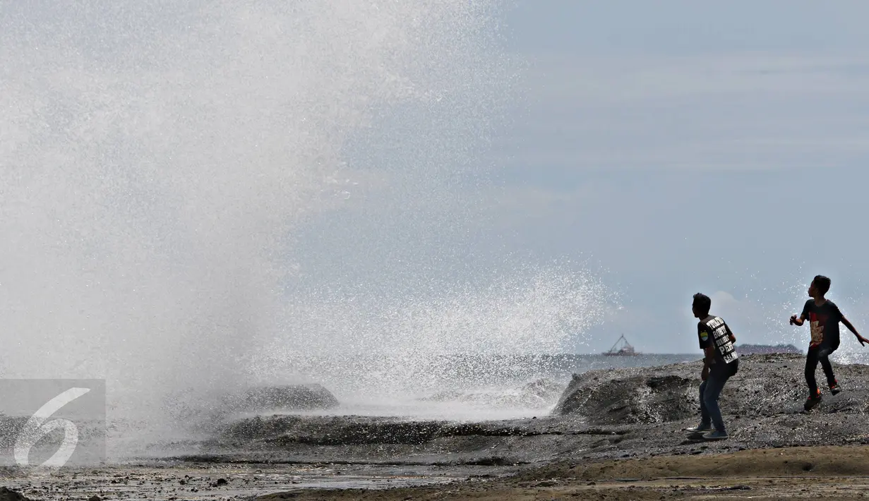 Warga bermain dengan ombak di pinggir Pantai Karang Hawu, Sukabumi, Jawa Barat, (8/2). Pantai Karang Hawu menjadi salah satu wisata murah meriah bagi wisatawan dalam mengisi hari libur. (Liputan6.com/Immanuel Antonius)