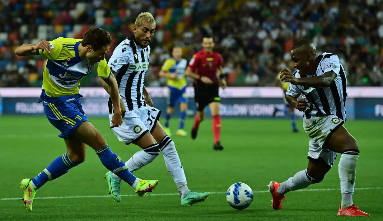 Pemain Juventus Federico Chiesa (kiri) mengoper bola saat melawan Udinese pada pertandingan Liga Italia Serie A di Dacia Arena Stadium, Udine, Italia, 22 Agustus 2021. Pertandingan berakhir dengan skor 2-2. (MIGUEL MEDINA/AFP)