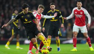 Pemain Manchester United, Lisandro Martinez, melindungi bola dari hadangan pemain Arsenal, Martin Odegaard, dalam pertandingan Liga Inggris di Emirates Stadium, Minggu (25/1/2026) malam WIB. (AP Photo/Kirsty Wigglesworth)
