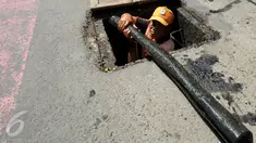 Petugas PPSU menemukan kulit kabel di gorong-gorong saluran air Jalan Gatot Subroto, Jakarta Selatan, Senin (6/3). Kulit kabel ini dianggap menjadi penyebab utama terjadinya banjir di Jalan Gatot Subroto pada 2 Maret 2017 lalu. (Liputan6.com/Johan Tallo)