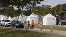 Petugas mengarahkan mobil warga ke lokasi vaksinasi virus corona COVID-19 drive-thru di Vista View Park, Davie, Florida, Amerika Serikat, 4 Januari 2021. Lokasi vaksinasi COVID-19 drive-thru tersebut disiapkan untuk penduduk Broward yang berusia 65 tahun ke atas. (Joe Raedle/Getty Images/AFP)