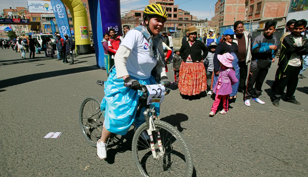 Peserta melewati garis finish dalam balapan sepeda Cholita dimulai di El Alto, La Paz, Bolivia (29/10). Balapan ini hanya diikuti oleh wanita yang mengenakan rok warna-warni tradisional setempat. (Reuters/David Mercado)