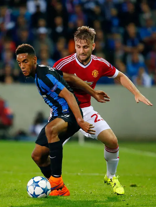 Bek MU, Luke Shaw (kanan) berebut bola dengan bek Club Brugge Jean Charles Castelletto saat pertandingan Play – Off  Liga Champion di Stadion Jan Breydel, Belgia, Rabu (26/8/2015). Gol MU dicetak oleh Wayney Rooney dan Ander Herrera. (Reuters/Yves Herman)