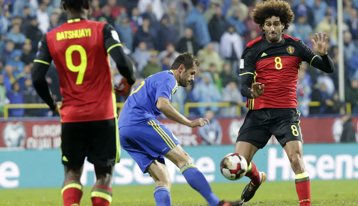 Pemain Bosnia, Senad Lulic (kiri) mencoba melewati adangan Marouane Fellaini (kanan) pada kualifikasi Piala Dunia 2018 grup H di Grbavica stadium, Sarajevo, Bosnia, (7/10/2017). Belgia menang 4-3. (AP/Amel Emric)