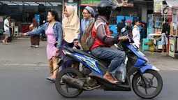 Senyum biarawati saat bergandeng tangan dengan wanita berkerudung ketika menyeberangi jalan di Lenteng Agung, Jakarta, Rabu (18/4). Keharmonisan keduanya dapat menjadi contoh bagi masyarakat dalam menjaga kedamaian. (Liputan6.com/Immanuel Antonius)