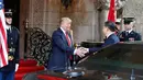 Presiden AS, Donald Trump menjabat tangan Presiden China, Xi Jinping saat menyambut kedatangannya di resor Mar a Lago, Florida, Kamis (6/4). Kedua pemimpin negara tersebut diagendakan akan menghabiskan waktu bersama secara privat. (AP Photo/Alex Brandon)
