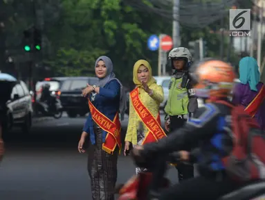 Personel Polisi Wanita (Polwan) Polres Jakarta Timur mengenakan pakaian kebaya saat mengatur arus lalu lintas di Jalan Otista Raya, Jatinegara, Jumat (20/4). Kegiatan tersebut dilakukan dalam rangka memperingati Hari Kartini. (Merdeka.com/Imam Buhori)