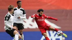 Gelandang Liverpool, Mohamed Salah (kanan) melepaskan tendangan yang masih melenceng dari gawang Fulham dalam laga lanjutan Liga Inggris 2020/21 di Anfield Stadium, Minggu (7/3/2021). Liverpool kalah 0-1 dari Fulham. (AFP/Clive Brunskill/Pool)