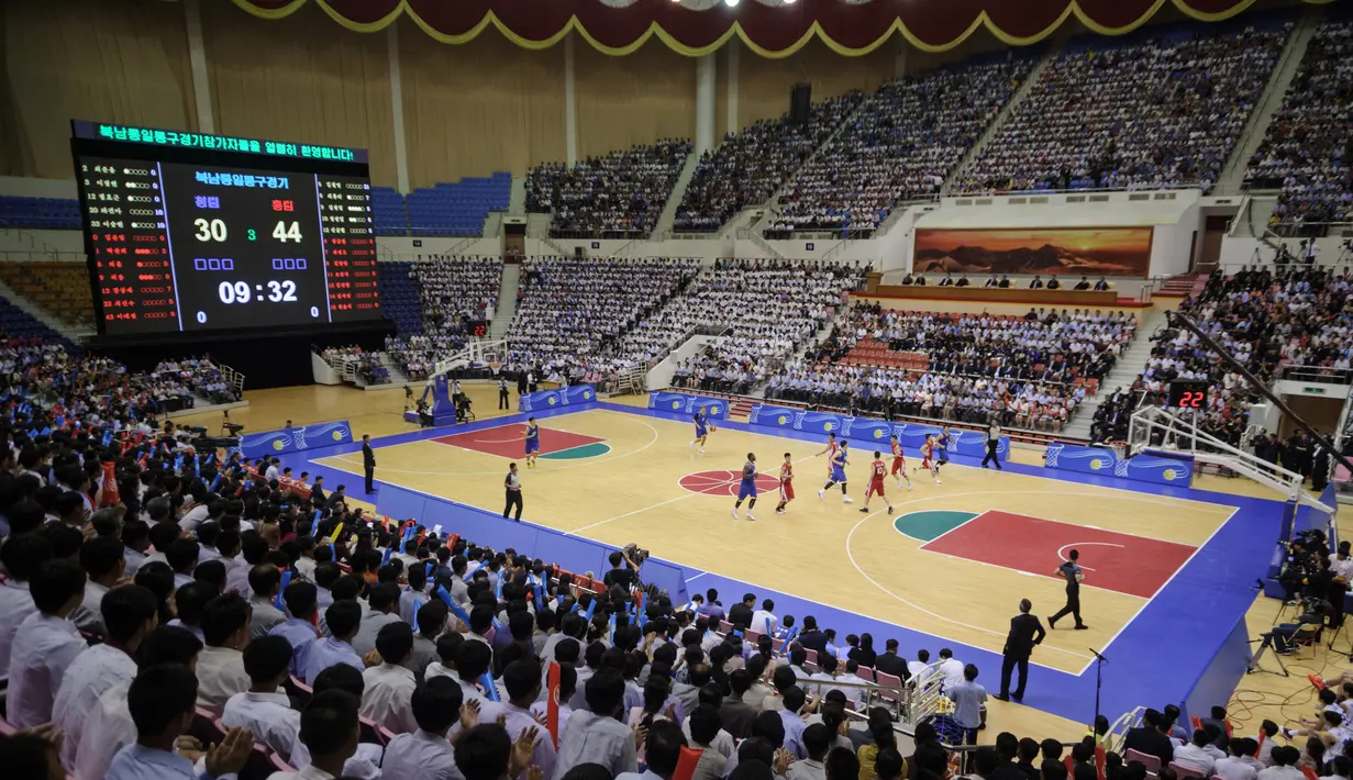 Suasana pertandingan basket antara Korea Utara (merah) dan Korea Selatan  (biru) di Stadion Indoor Ryugyong Chung Ju-Yung, Pyongyang (5/7). Tim pria Korea Utara memenangkan 82-70. (AFP Photo/Kim Won-Jin)