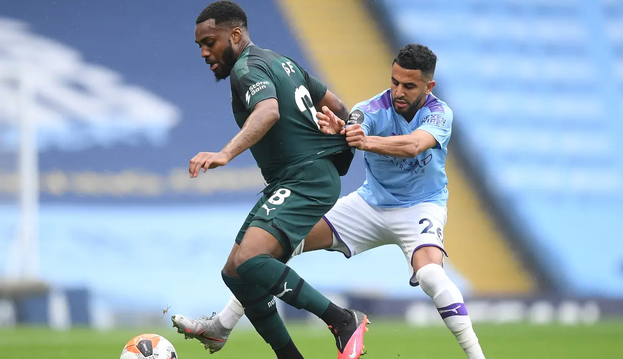 Gelandang Manchester City, Riyad Mahrez, berebut bola dengan bek Newcastle United, Danny Rose, pada laga lanjutan Premier League pekan ke-34 di Etihad Stadium, Kamis (9/7/2020) dini hari WIB. Manchester City menang 5-0 atas Newcastle. (AFP/Michael Regan/pool)
