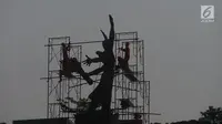 Pekerja memasang rangka besi untuk membersihkan Patung Selamat Datang di Bundaran HI, Jakarta, Sabtu (4/8). Patung Selamat Datang dibersihkan untuk perhelatan Asian Games 2018 yang akan berlangsung pertengahan Agustus bulan ini. (Merdeka.com/Imam Buhori)