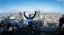 Pembalap sepeda asal Prancis, Aurelien Fontenoy, melakukan selebrasi usai mendaki 768 anak tangga dari 33 lantai gedung Trinity Tower di distrik La Defense, Paris, (17/1/2021). (AFP/Martin Bureau)