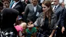 Ratu Rania dari Yordania (kanan) membelai seorang bayi dengan luka bakar saat kunjungannya ke kamp pengungsi Kara Tepe di pulau Yunani, Lesbos, Senin (25/4). (REUTERS/Alkis Konstantinidis)