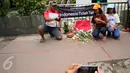 Warga berfoto di dekat poster #Indonesiatidaktakut yang dipasang di depan Menara Cakrawala, Jakarta, Sabtu (16/1). Lokasi teror di kawasan Sarinah Thamrin terus didatangi warga untuk mengabadikan diri atau foto selfie. (Liputan6.com/Faizal Fanani)