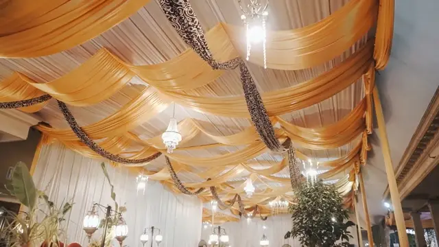 Dominasi warna emas dan putih serta lampu penerang di lokasi resepsi pernikahan Gus Iqdam dan Ning Nila (SS: YT. Gus Iqdam Official)