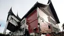 Warga melintas di depan bangunan yang rusak akibat gempa Tsunami, Padang (10/10/2009). Kini ilmuwan Indonesia dan AS tengah mengembangkan alat pendeteksi Tsunami yang lebih canggih. (AP Photo/ Achmad Ibrahim)